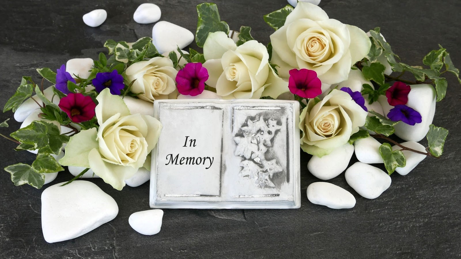 Photo of a bouquet of flowers and a book that says "In Memory"