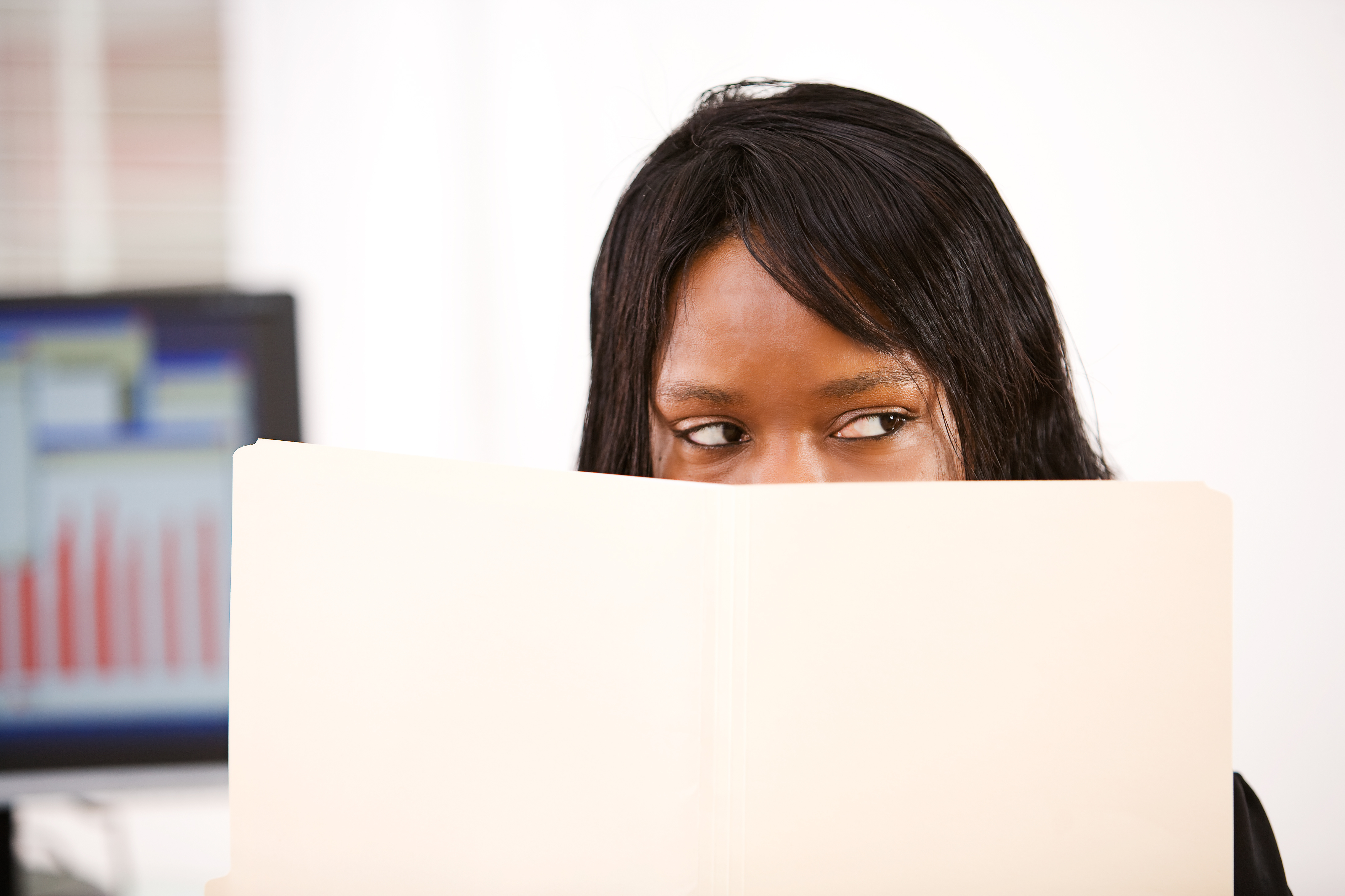 women peeking over folder